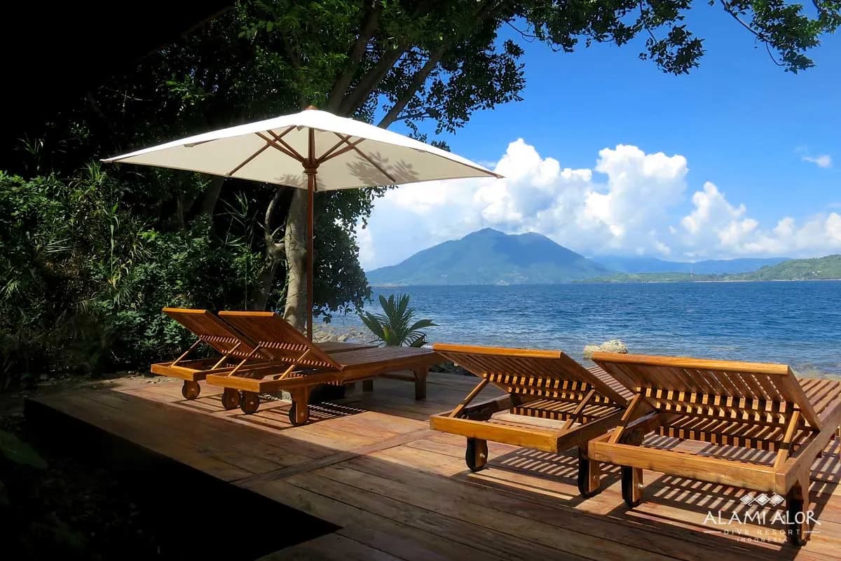 Lounge chairs and an umbrella on the beach at Alami Alor resort. Lounge chairs and an umbrella on the beach at Alami Alor resort.