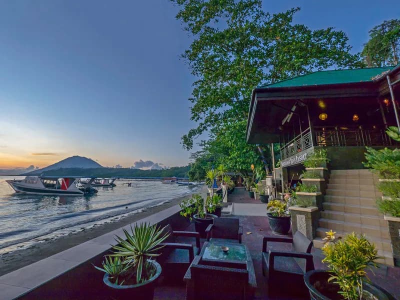 A resort overlooks the sea with dive boats floating in the water A resort overlooks the sea with dive boats floating in the water