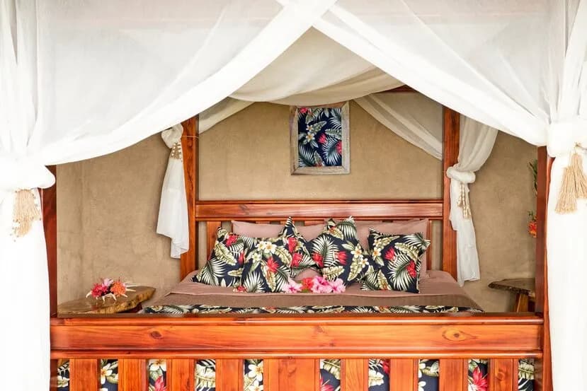 A bed with a mosquito net in a room at Paradise Taveuni A bed with a mosquito net in a room at Paradise Taveuni