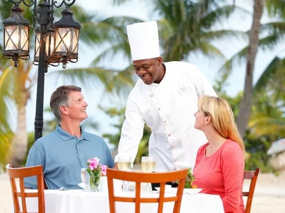 A chef serves two people a meal at Cayman Brac Beach Resort A chef serves two people a meal at Cayman Brac Beach Resort
